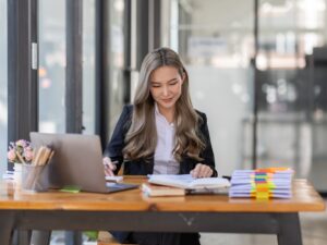 business Asian woman or accountant Bookkeeper working on calculator to calculate business data,