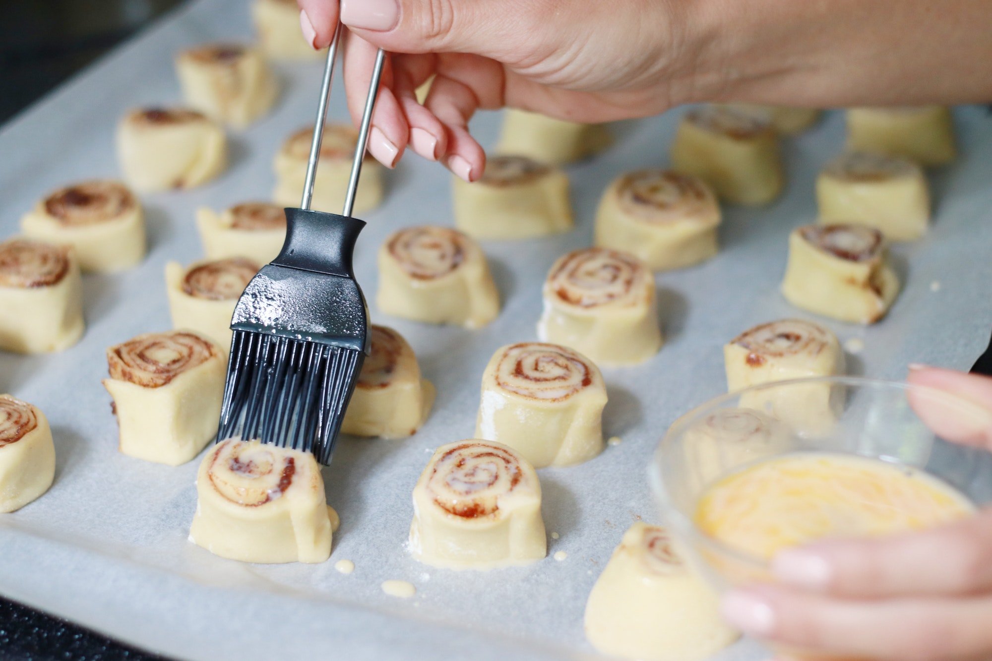 A woman backing a cinnamon roll cookies.