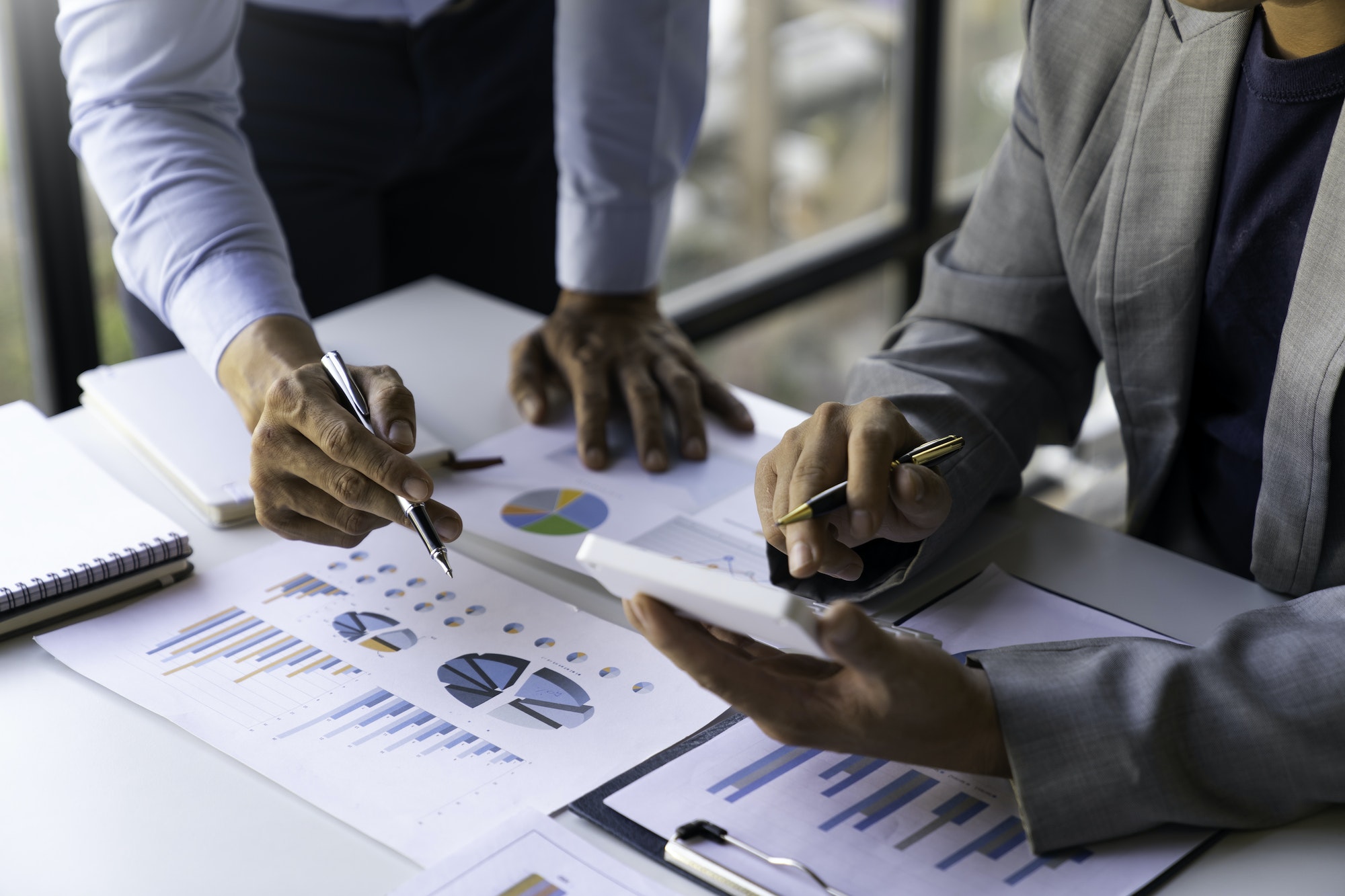 Business executives analyze data documents and calculating about fee tax at an office Image of busin