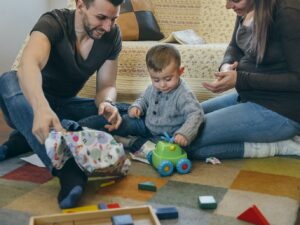 Parents with their little son opening a gift